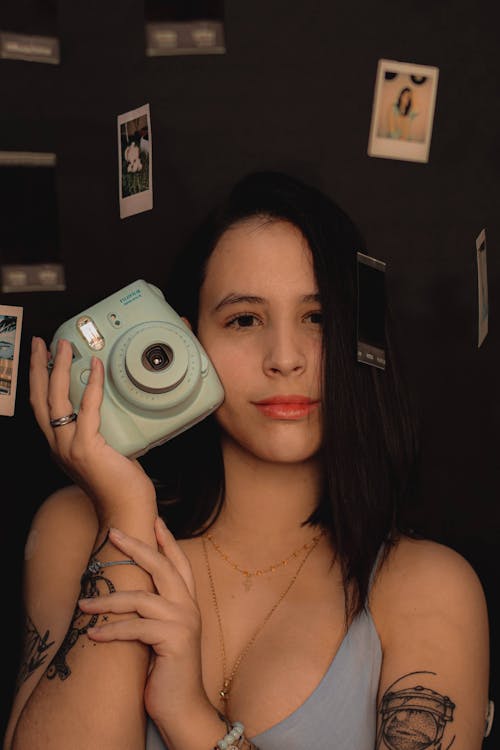 A Woman Holding a Polaroid Camera