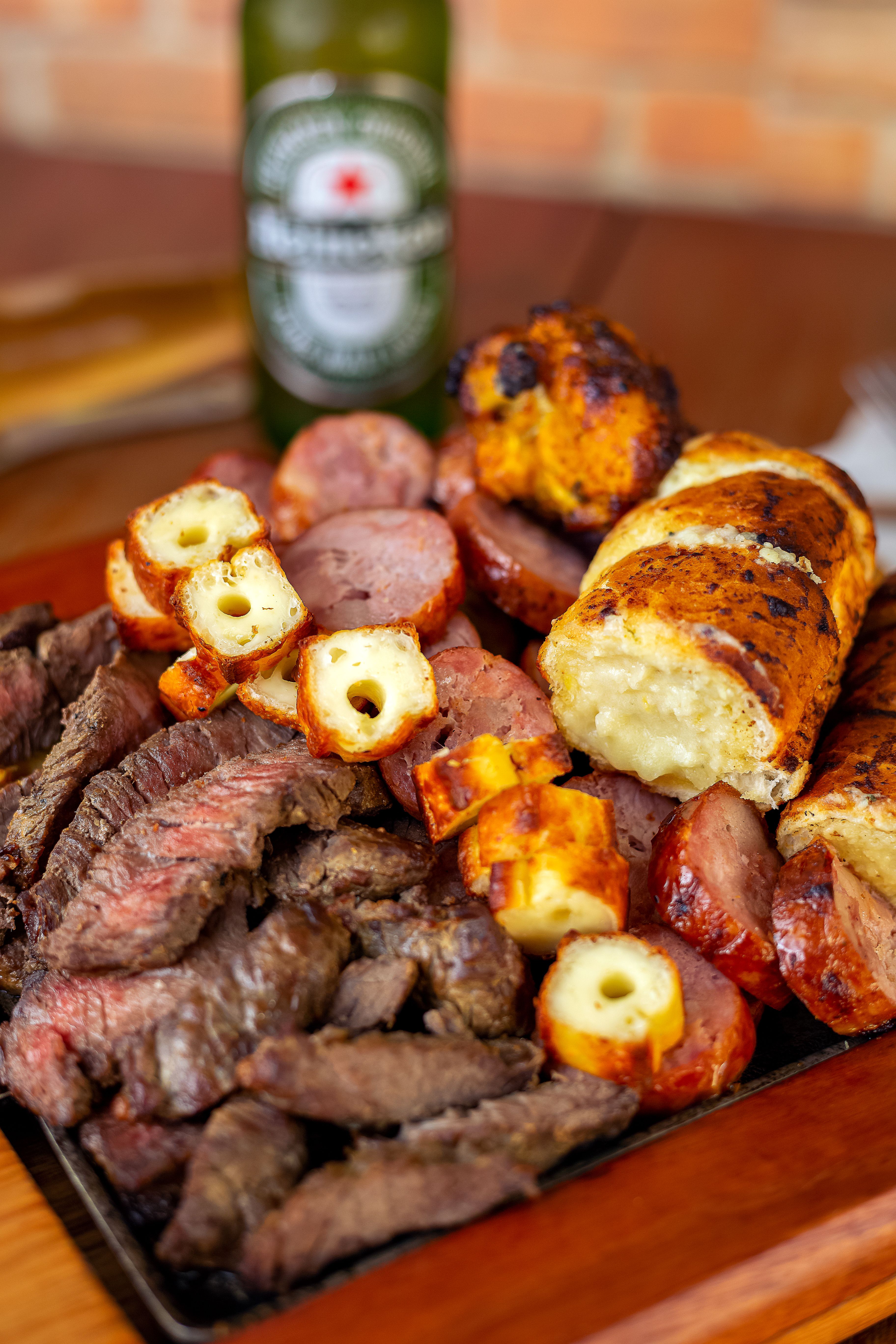 Delicious assortment of grilled meats and sausages on a wooden platter, perfect for a barbecue feast.