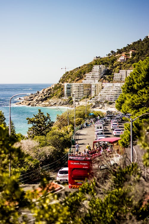 Carros Na Estrada Perto Do Mar Azul E Montanhas Cobertas De Verde