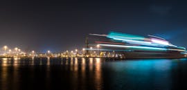 这张长时间曝光的夜间港口照片呈现出戏剧性的光线轨迹和反射效果