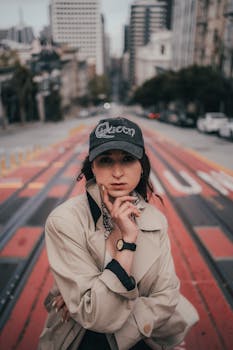 Stylish individual posing on a vibrant red street in the city, evoking urban fashion and lifestyle.