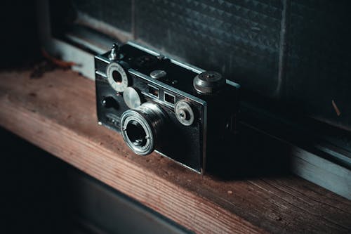 Black and Silver Camera on Brown Wooden Table