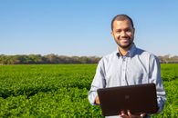 Man in White Dress Shirt Standing on Green Grass Field