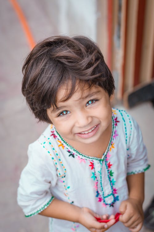 Girl Wearing Embroidered White Dress Smiling