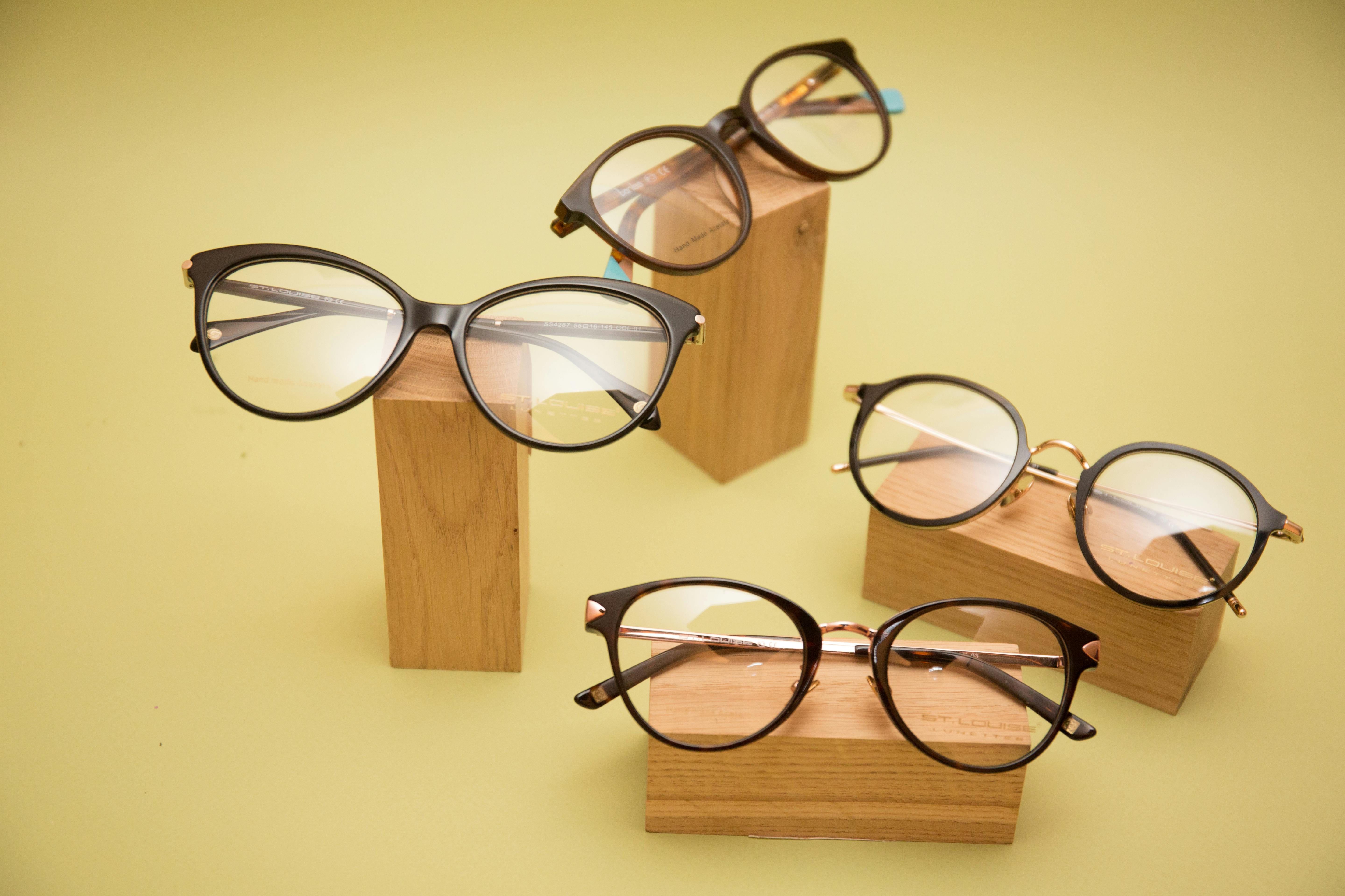 Modern eyeglasses artfully displayed on natural wooden blocks, ideal for fashion promotions.