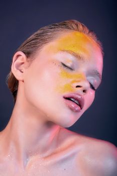 Colorful artistic portrait of a woman with vibrant makeup and eyes closed, exuding creativity.