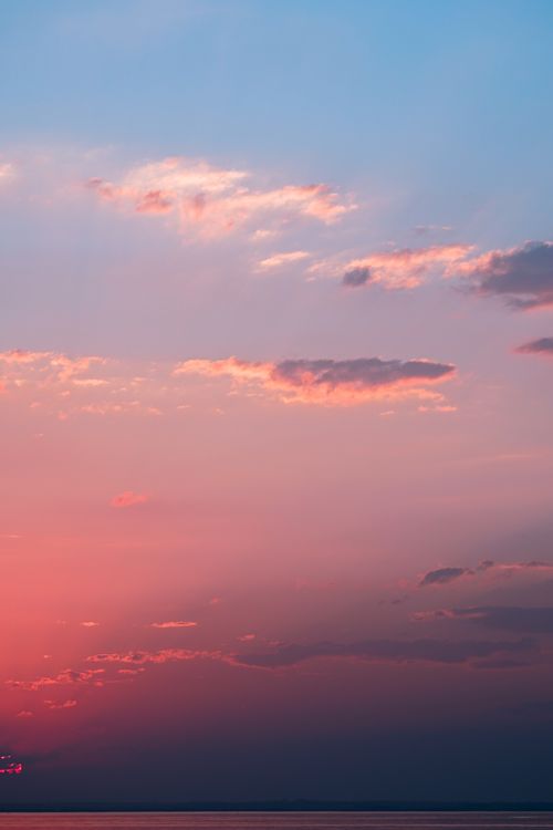 Free A dramatic sunset over the ocean with vivid hues of pink and blue, creating a breathtaking view. Stock Photo