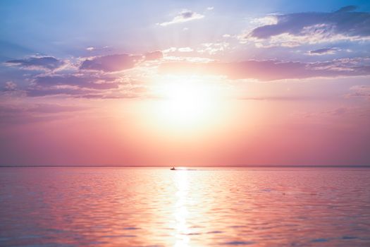 A breathtaking sunrise over the tranquil sea with dramatic clouds and vibrant colors.