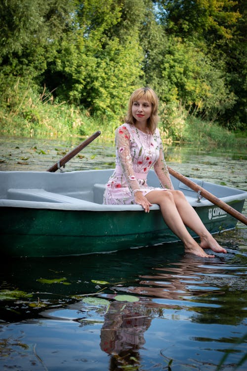 Woman in Floral Dress Sitting on Boat