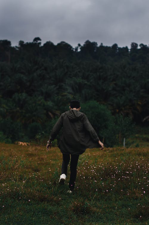 Man in Jacket Running on Grass