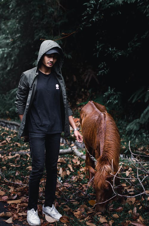 Man in Black Shirt Standing Beside a Pony