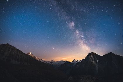 Star field above a dark alpine ridge at night — photo by Marek Piwnicki on Pexels