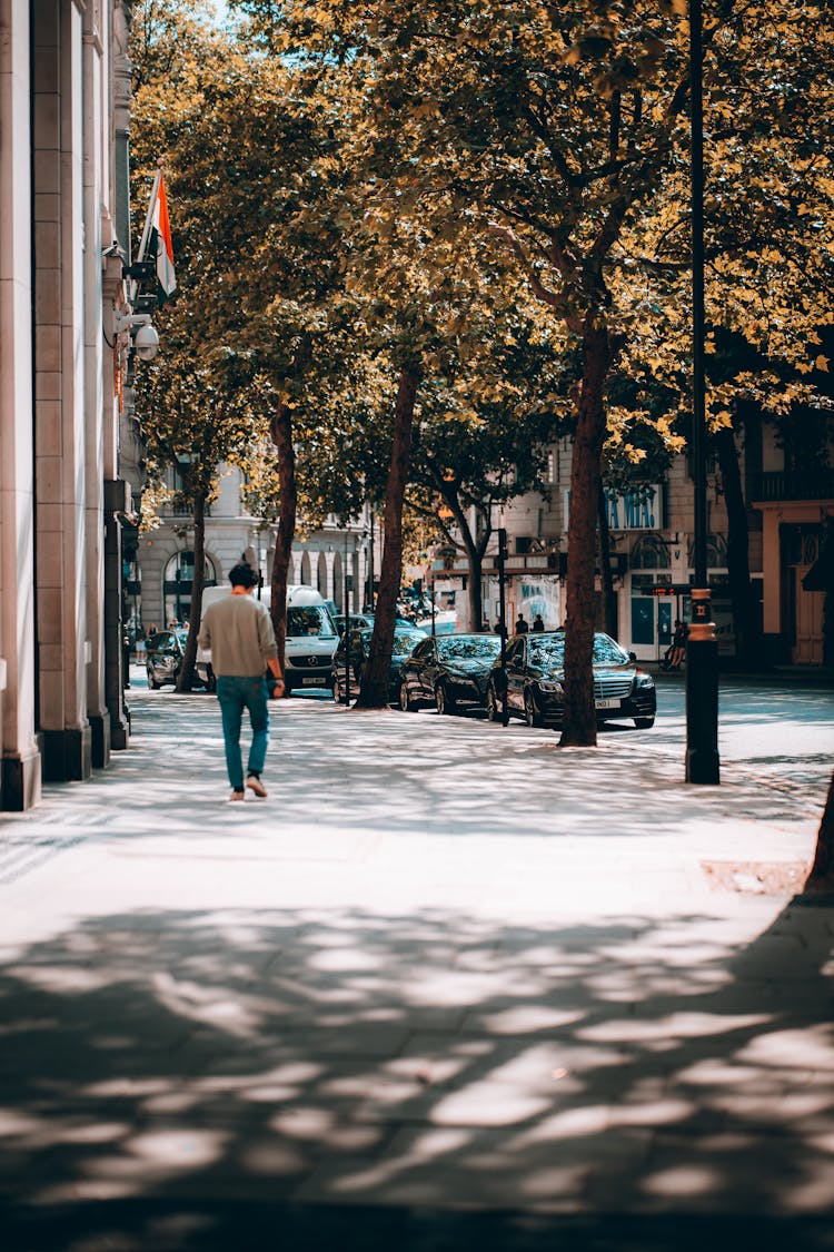 Man In Gray Long Sleeve Shirt Walking On Sidewalk