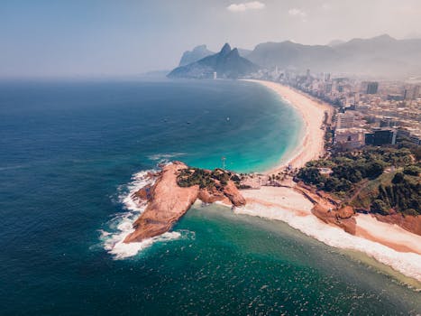 Stunning aerial view of Rio de Janeiro's coastline showcasing vibrant beaches and mountains in the distance.