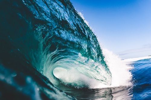 Free A stunning close-up of a crashing ocean wave with vibrant blue tones. Stock Photo