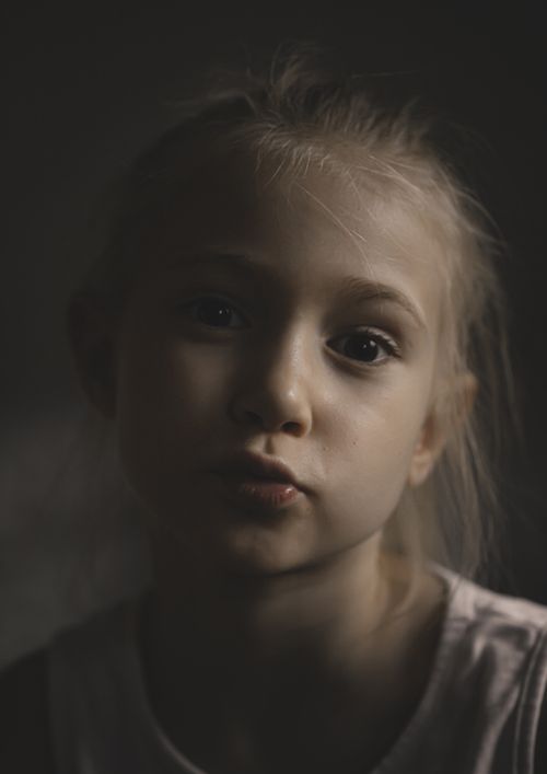 Free A soft portrait capturing the innocence and thoughtful expression of a young girl. Stock Photo