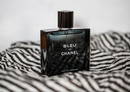 Free Elegant product shot of Bleu de Chanel perfume on striped fabric conveying luxury and sophistication. Stock Photo