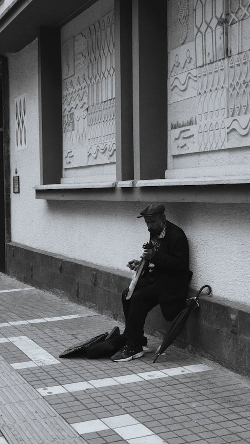 Elderly Man leaning on the Wall 