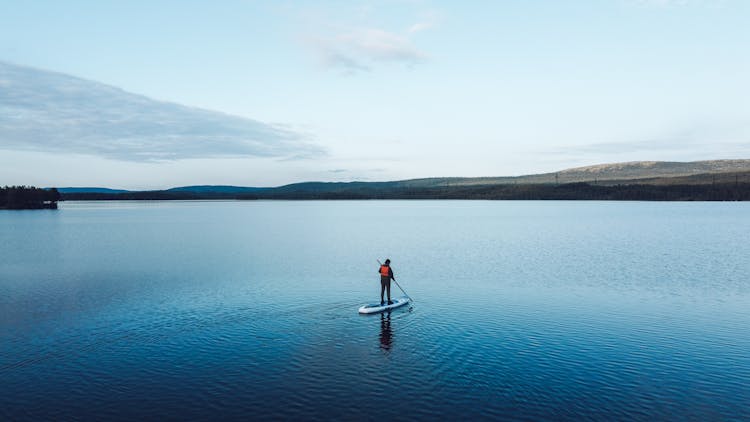 Man In Red Life Vest Paddle Boarding