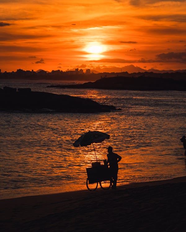 Silhouette of Vendor on Beachside during Golden Hour 