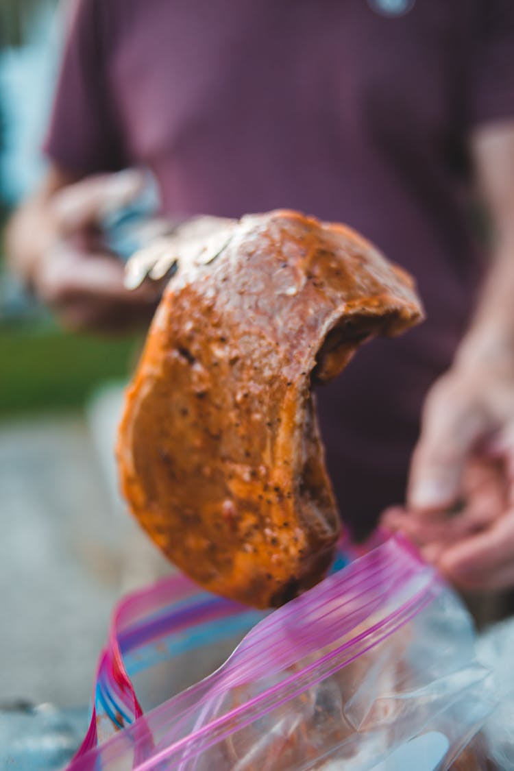 Person Holding A Marinated Steak 