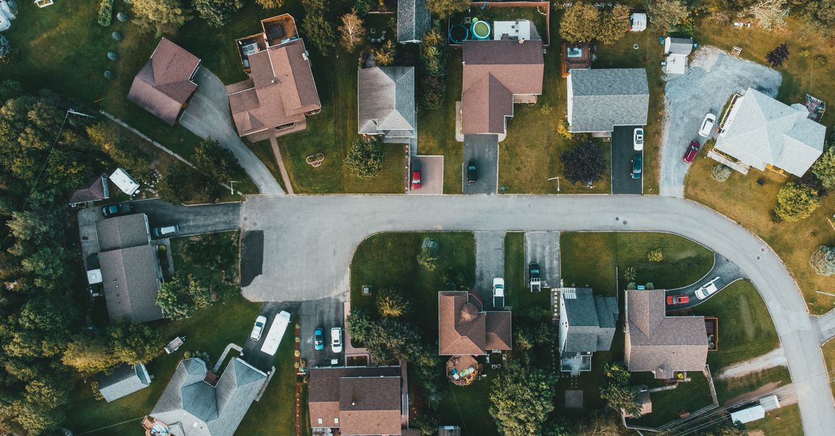 A top-down view of a suburban neighborhood showing houses, streets, and greenery.