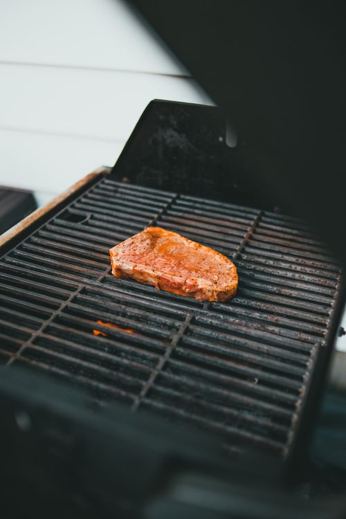 Free Juicy steak cooking on a grill, perfect for barbecue lovers. Stock Photo