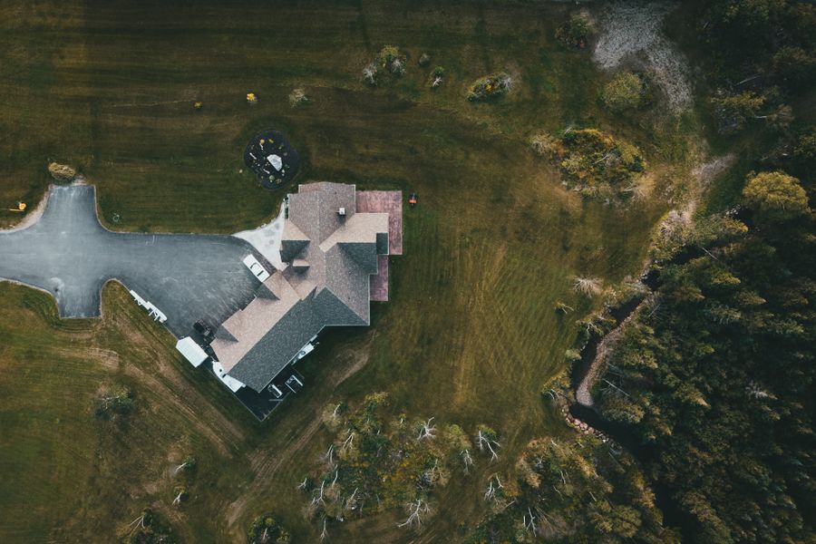 Aerial view of a suburban house surrounded by greenery