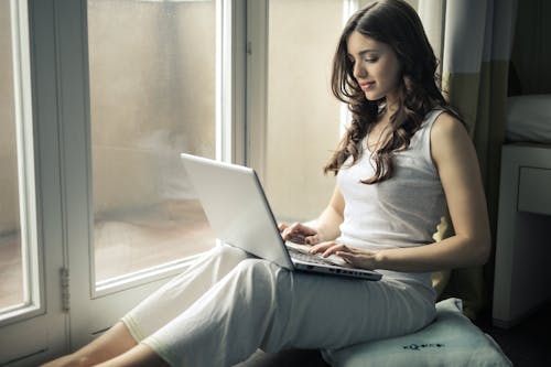 Free Woman Wearing Tank Top Sitting by the Window  Stock Photo