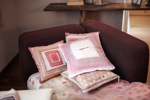 Vier Verschiedenfarbige Kissen Auf Gepolstertem Rotem Sofa