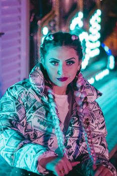 Stylish woman with braided hair and neon lights creates a vibrant portrait.