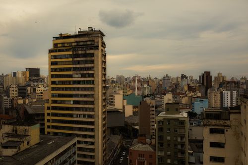 Free Aerial view of a cloudy urban skyline featuring diverse types of high-rise buildings. Stock Photo