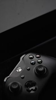 Stylish black Xbox controller close-up with buttons and joysticks on dark background.