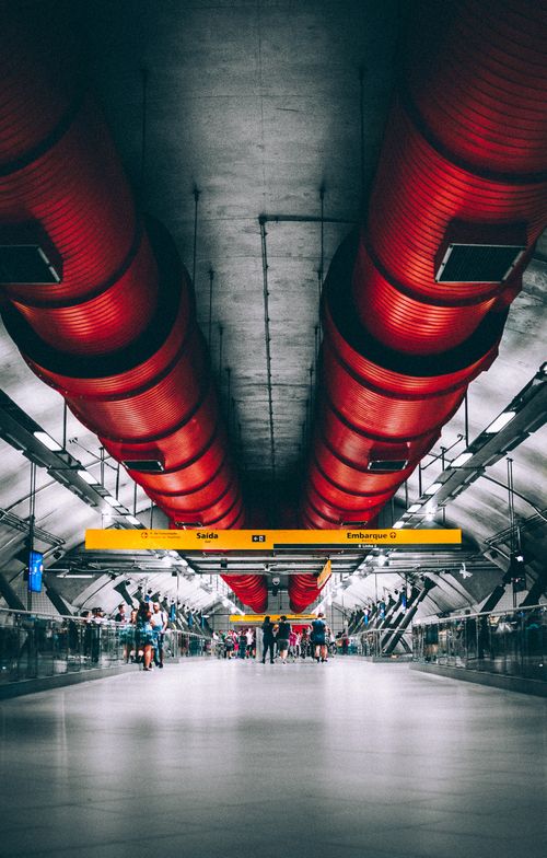 Free Vibrant São Paulo subway station interior with commuters and striking red accents. Stock Photo