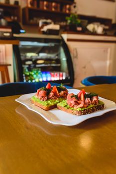 Savor mouthwatering avocado toast topped with fresh ingredients in a cozy café setting.