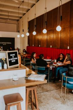 People enjoying a relaxing meal in a cozy and stylish coffee shop interior.