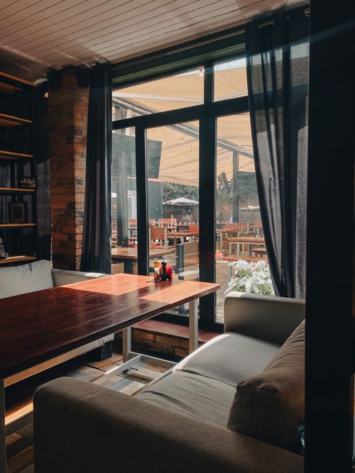 Free Warm and inviting café interior with natural light shining through large windows. Stock Photo
