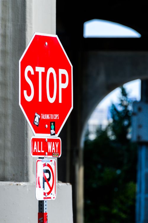 Free Colorful urban stop sign with no parking notice under a city underpass. Stock Photo