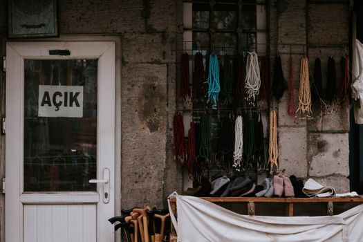 Outdoor display of colorful beads and accessories in front of an open door with Turkish sign.