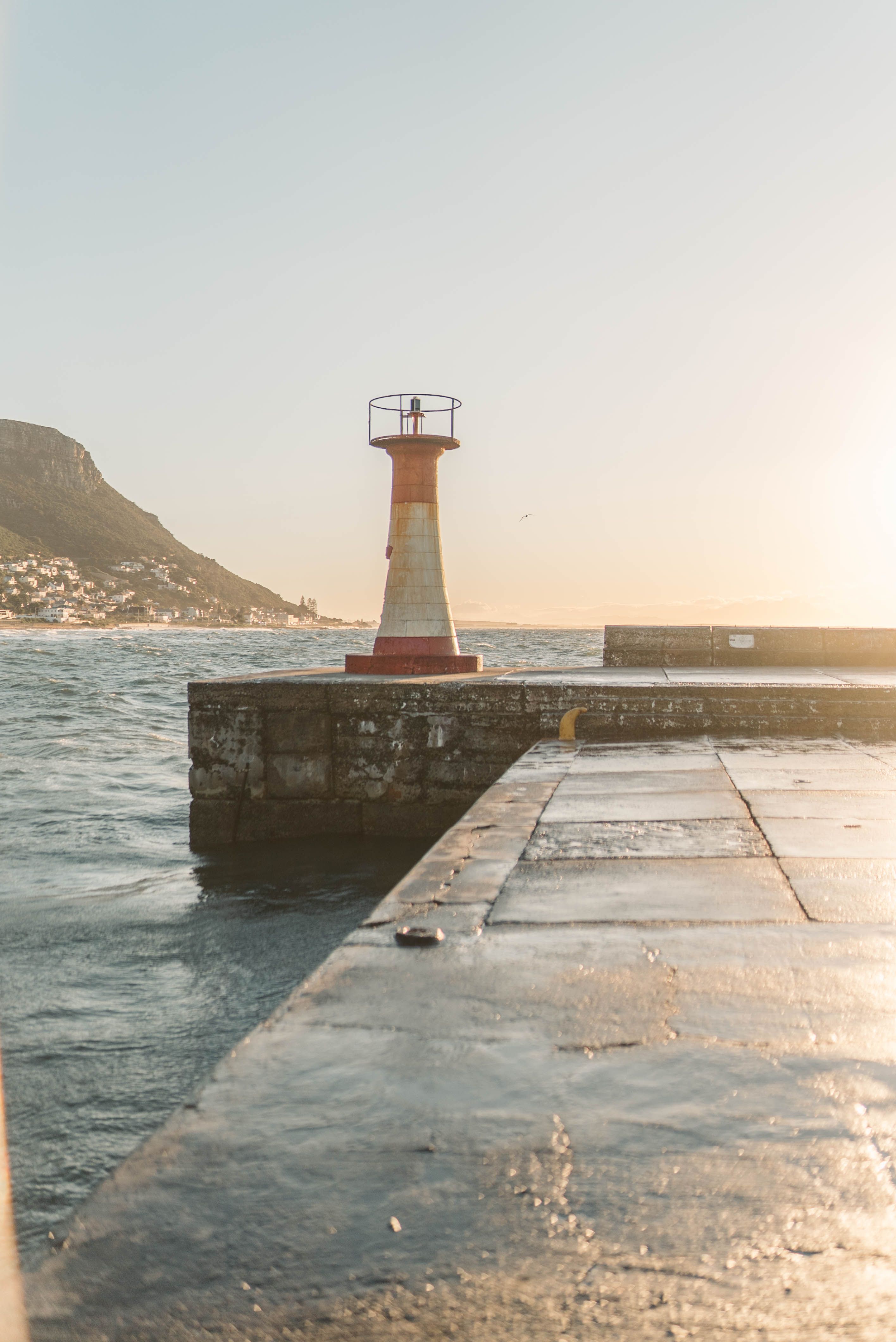 White and Red Lighthouse Near Body of Water · Free Stock Photo