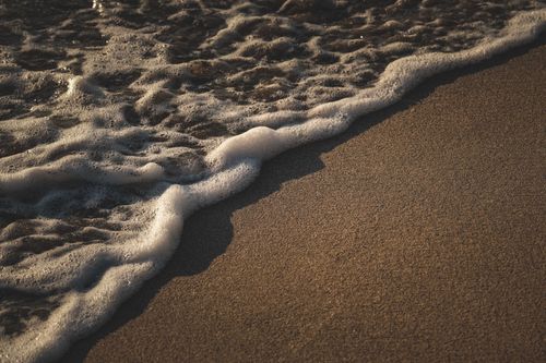 Free Detailed view of ocean waves meeting sandy shore, capturing the essence of nature. Stock Photo