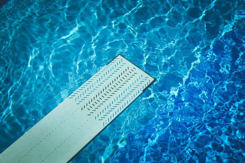 Belle piscine extérieure avec plongeoir en plein été