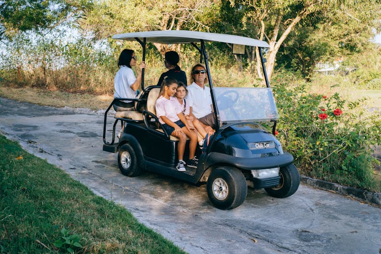 Family Riding On A Golf Cart 