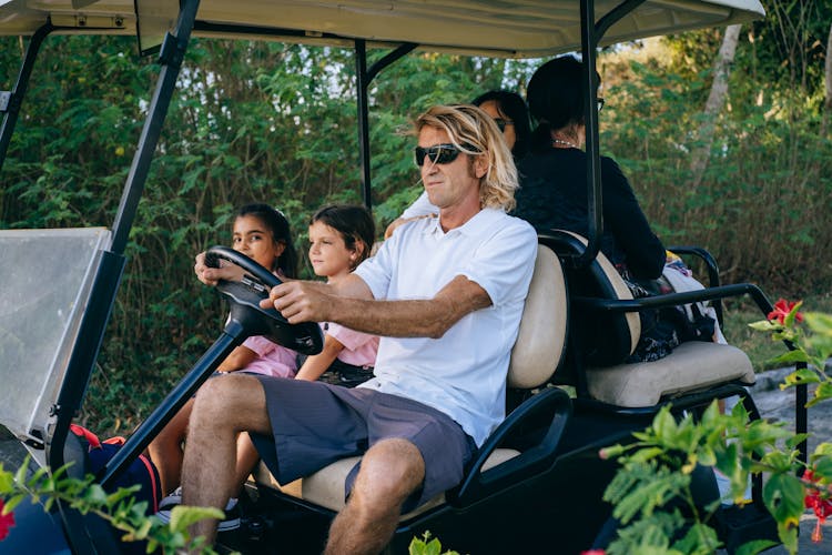 A Family Riding A Golf Cart