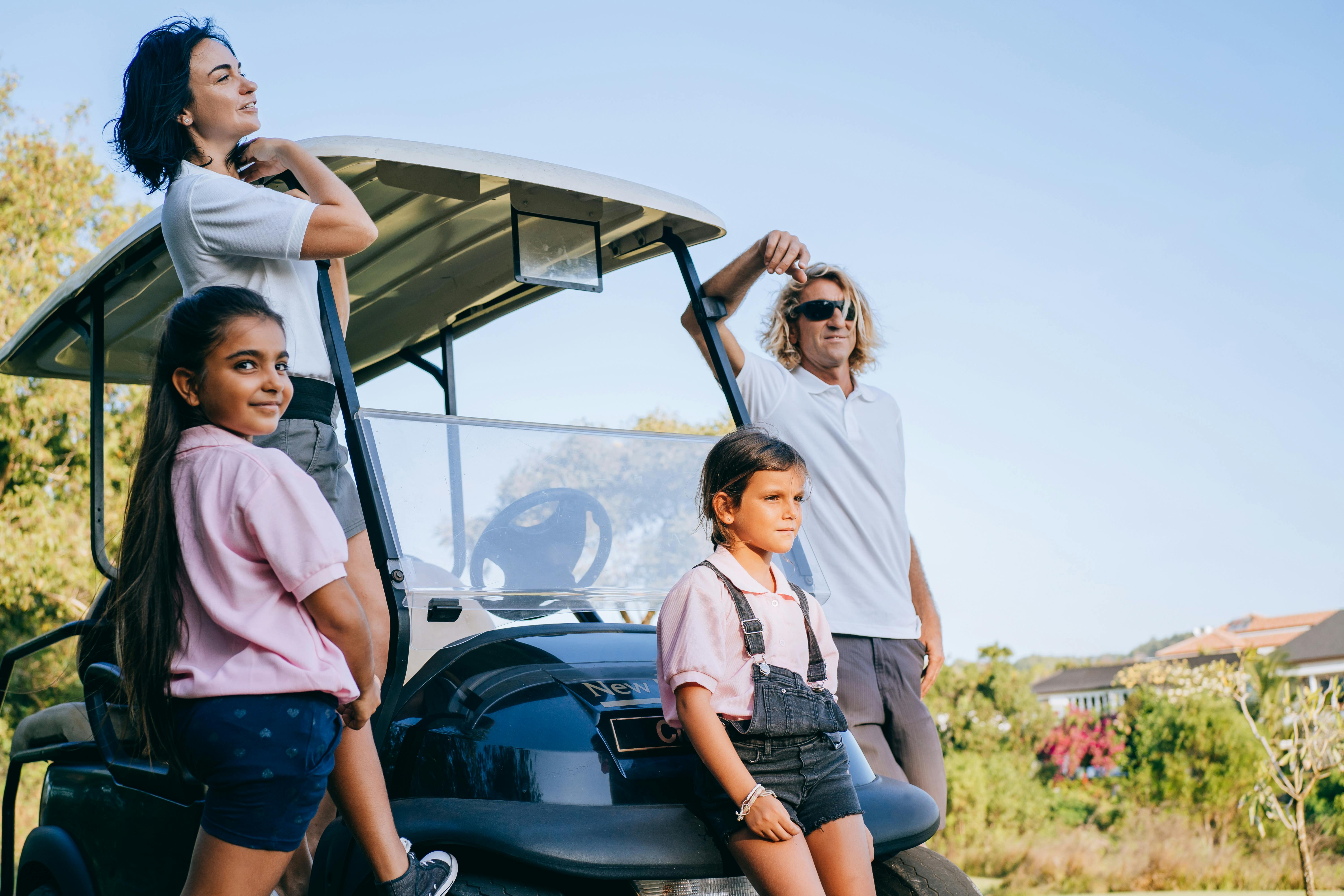 happy family beside black golf car