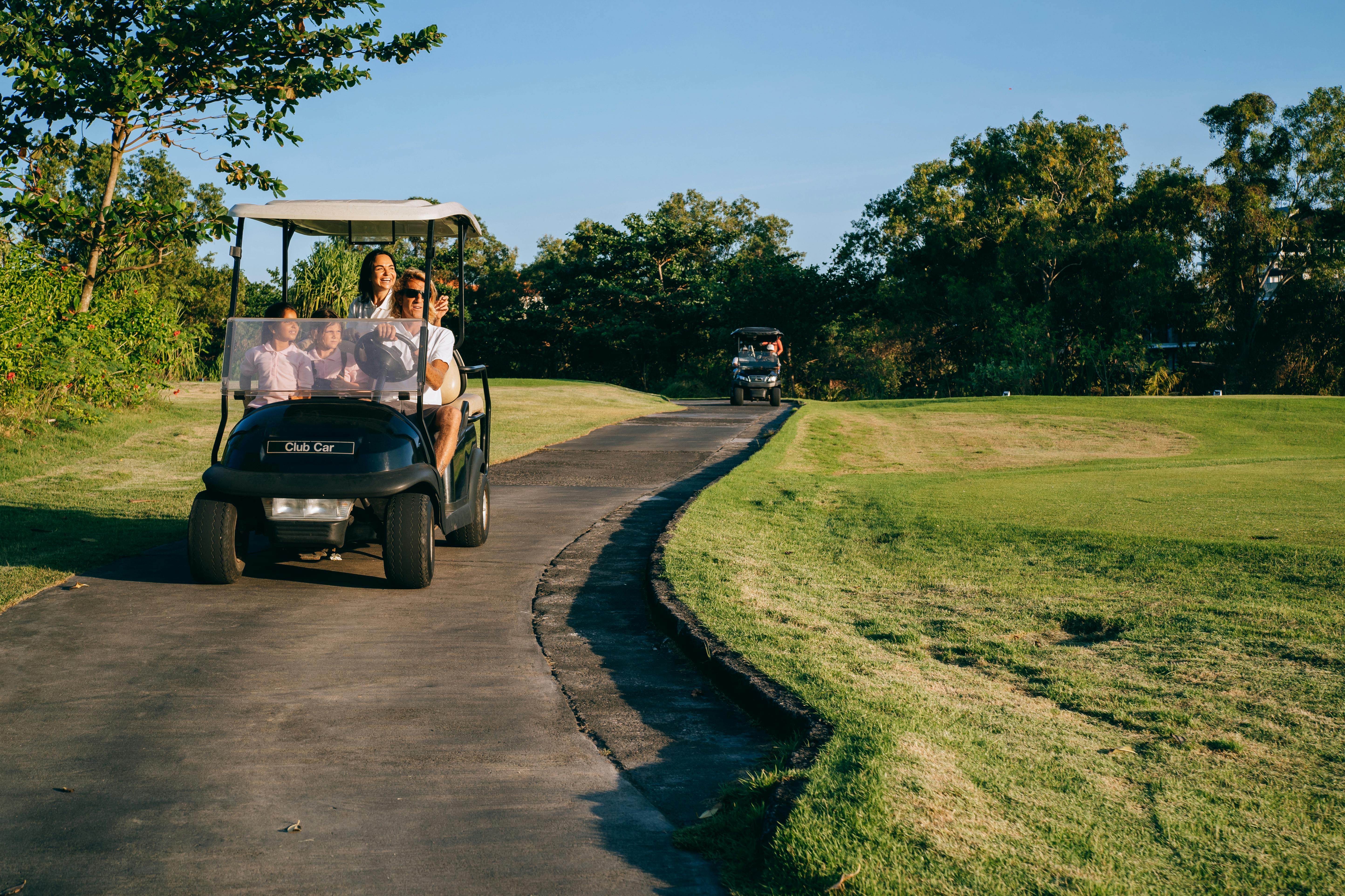 a family riding a golf cart