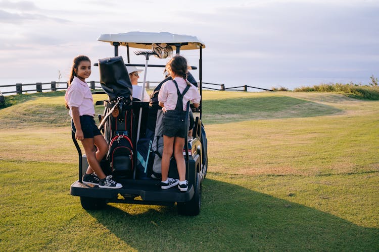 
A Family Riding A Golf Cart