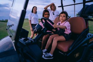 Kids Sitting on a Golf Cart with Their Parents