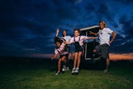 Family Standing on Golf Course Beside a Golf Cart