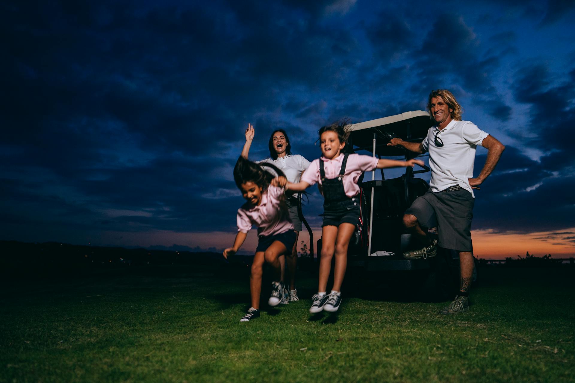 Family Standing on Golf Course Beside a Golf Cart